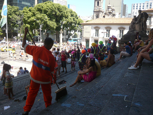 Comlurb street cleaner sweeping up trash during a bloco held at Praça XV