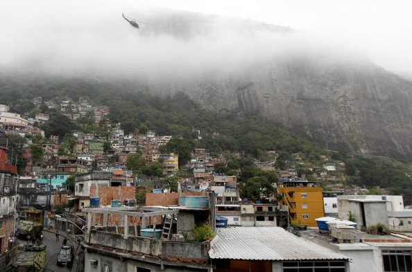 ﻿A helicopter circles the steep banks of Rocinha during the Sunday occupation operation, Rio de Janeiro, Brazil