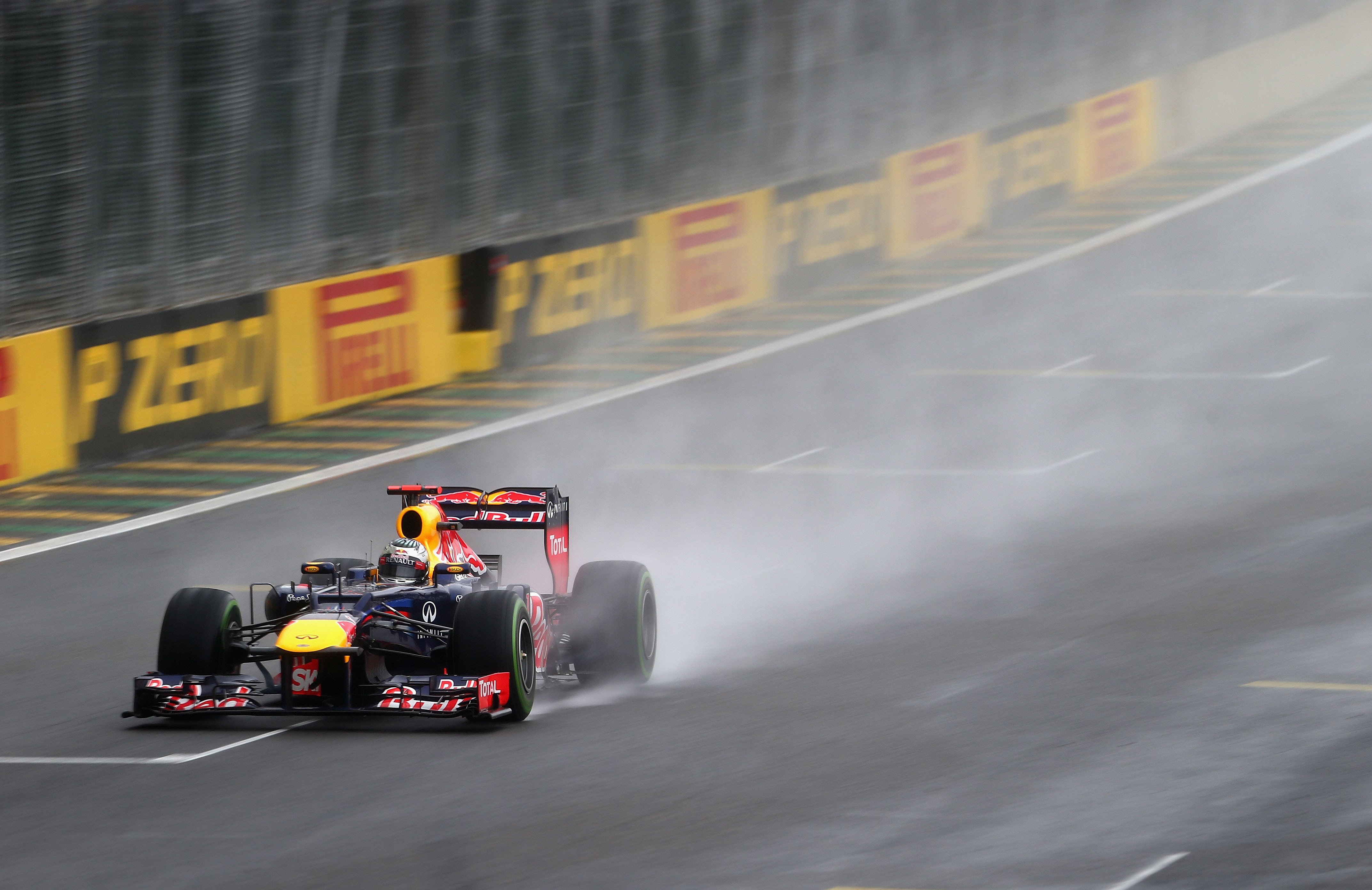 A Formula 1 car throws up spray on the wet main straight at Interlagos in São Paulo