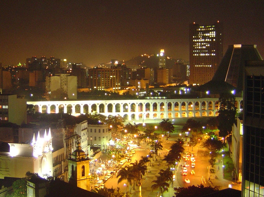 The Lapa Arches lit up at night above the streets of central Rio de Janeiro