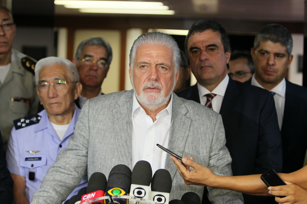 Man with beard at press conference with microphones