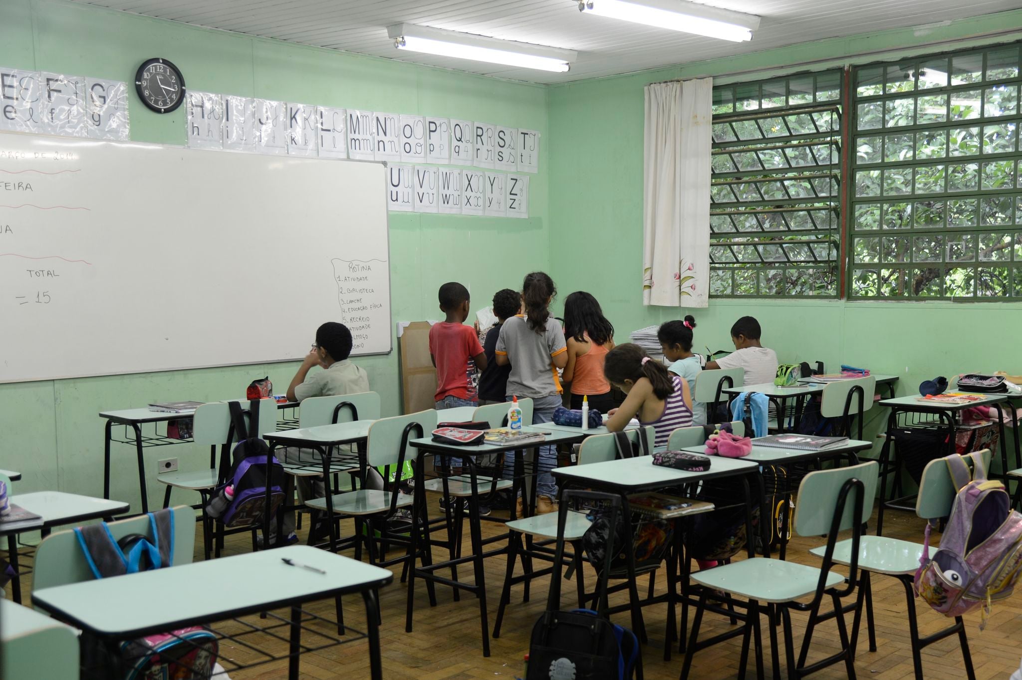 Children at their desks in a Brazilian primary-school classroom, seen from behind