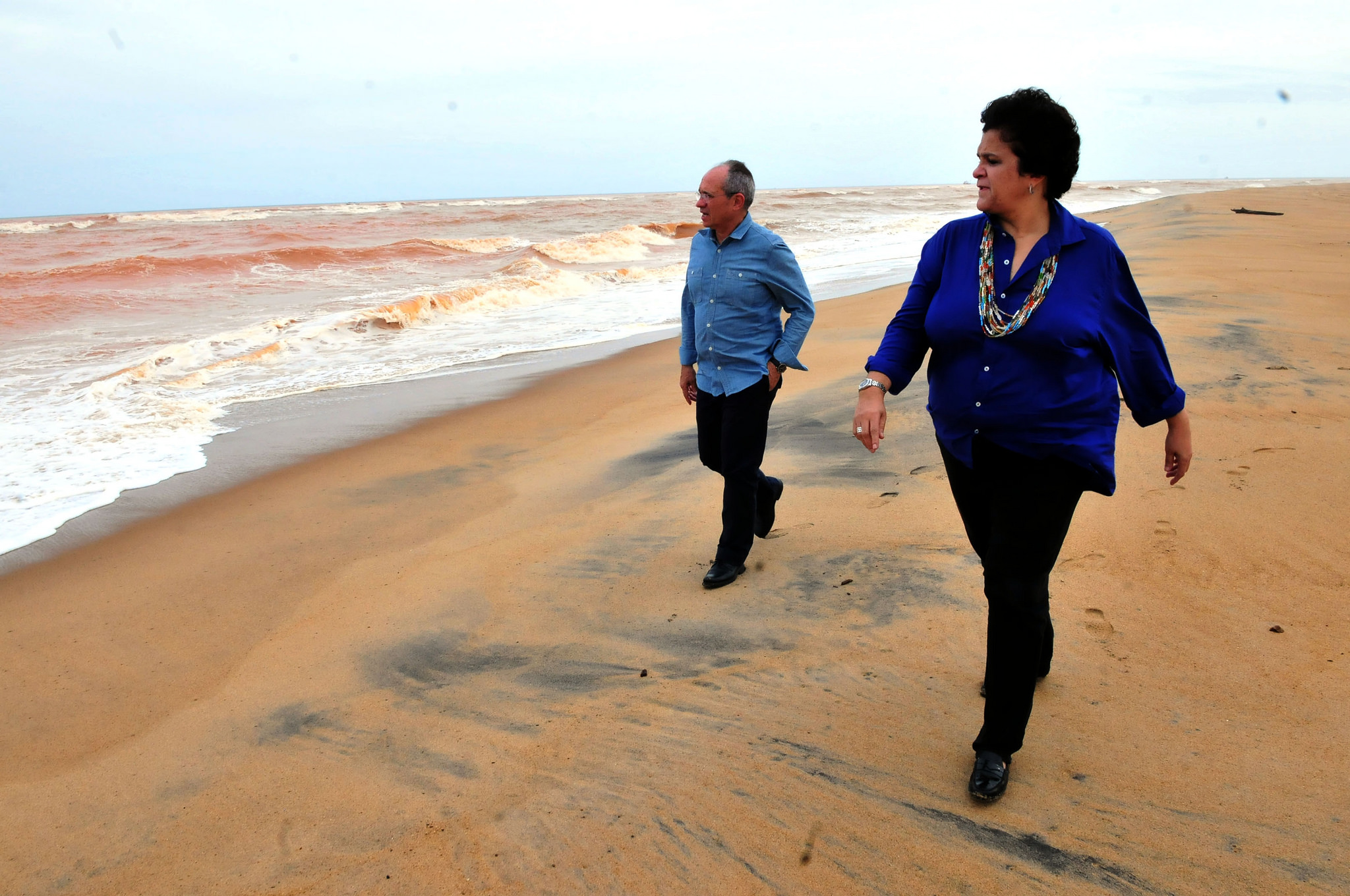 Espirito Santo governor, Paulo Hartung and Environment Minister Izabella Teixeira walk along coastline already polluted with toxic mud, Brazil