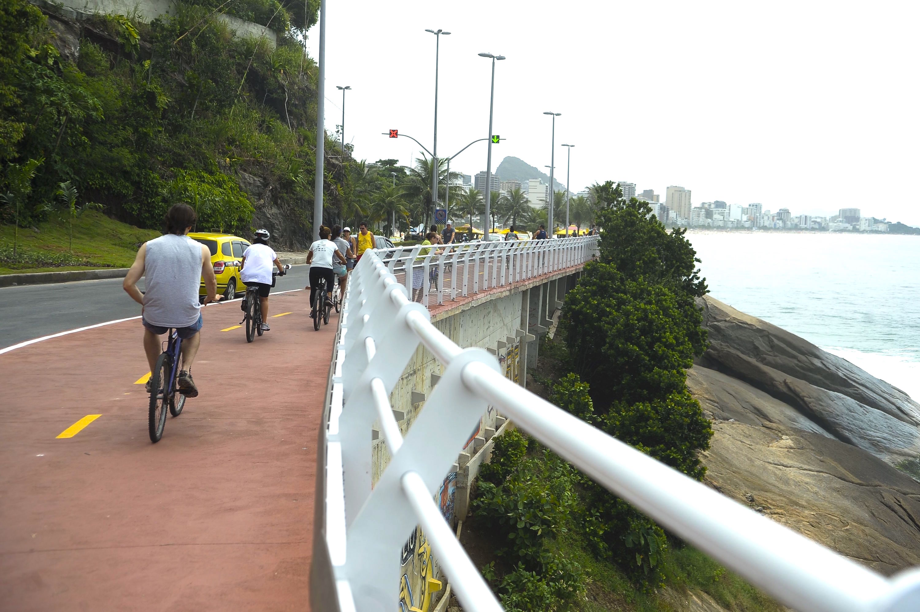 Cyclists riding a seafront bike path in Rio de Janeiro