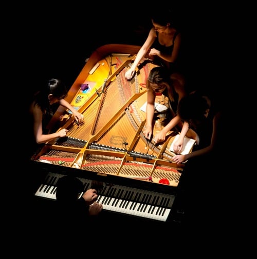Performers at a grand piano seen from above, illustrating the Festival Nelson Freire