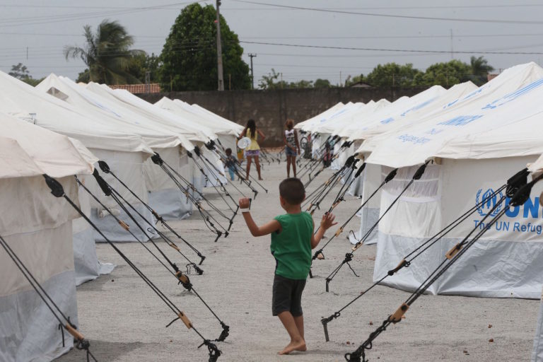 Brazil,Venezuelan boy plays along the dozens of tents set up in Boa Vista, Roraima for refugees.