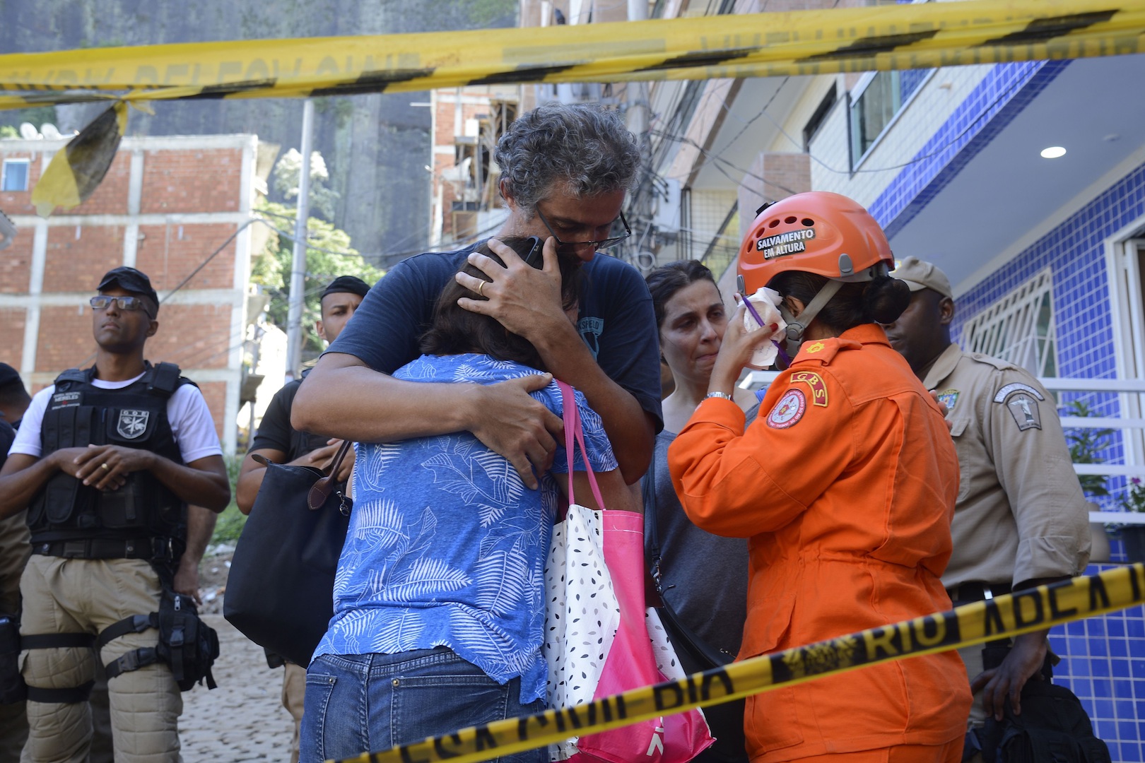 Brazil, Family members and friends wait for word from firefighters about victims trapped in the rubble in the Muzema favela community.