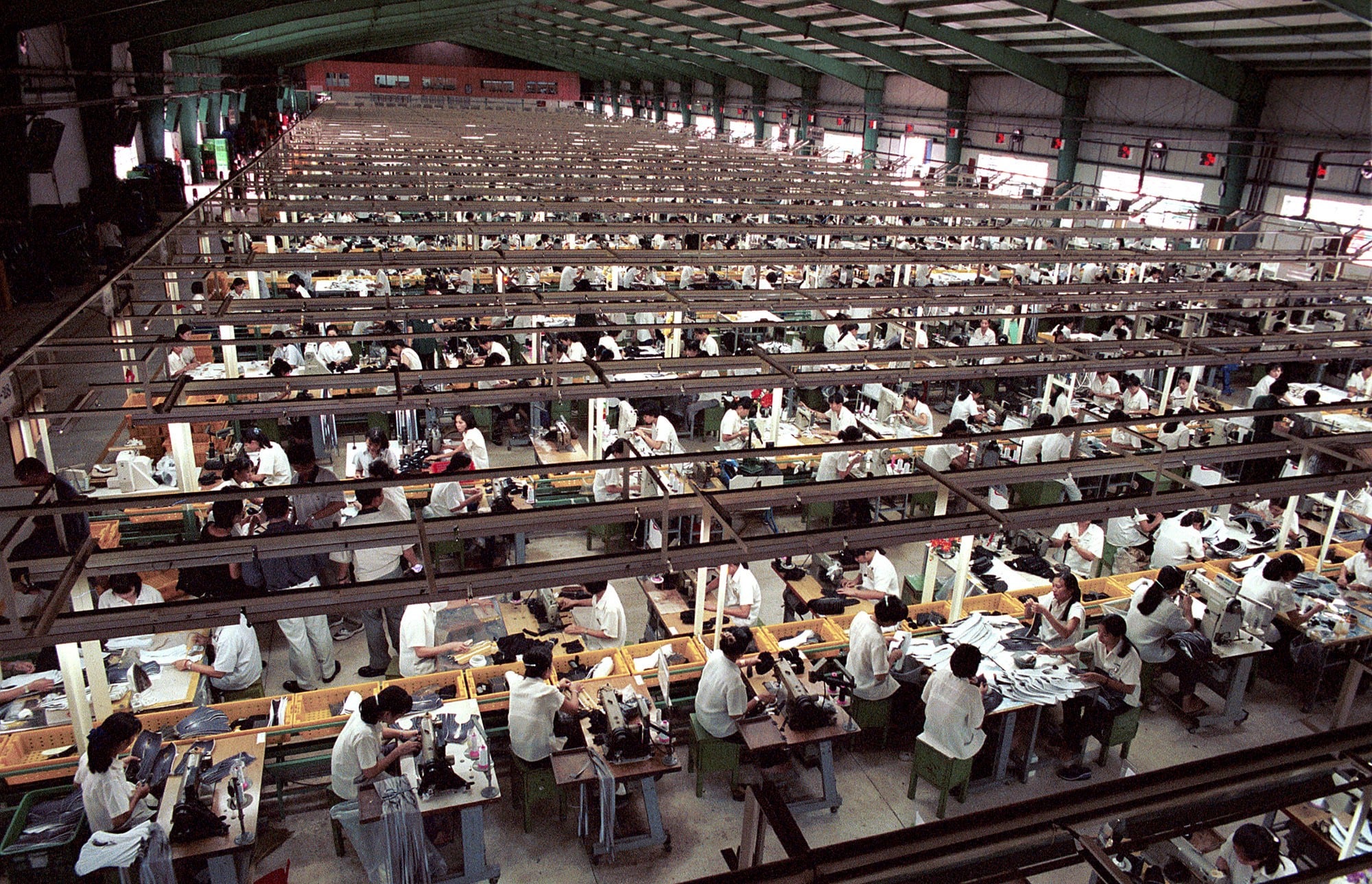 Workers at benches on a garment factory floor
