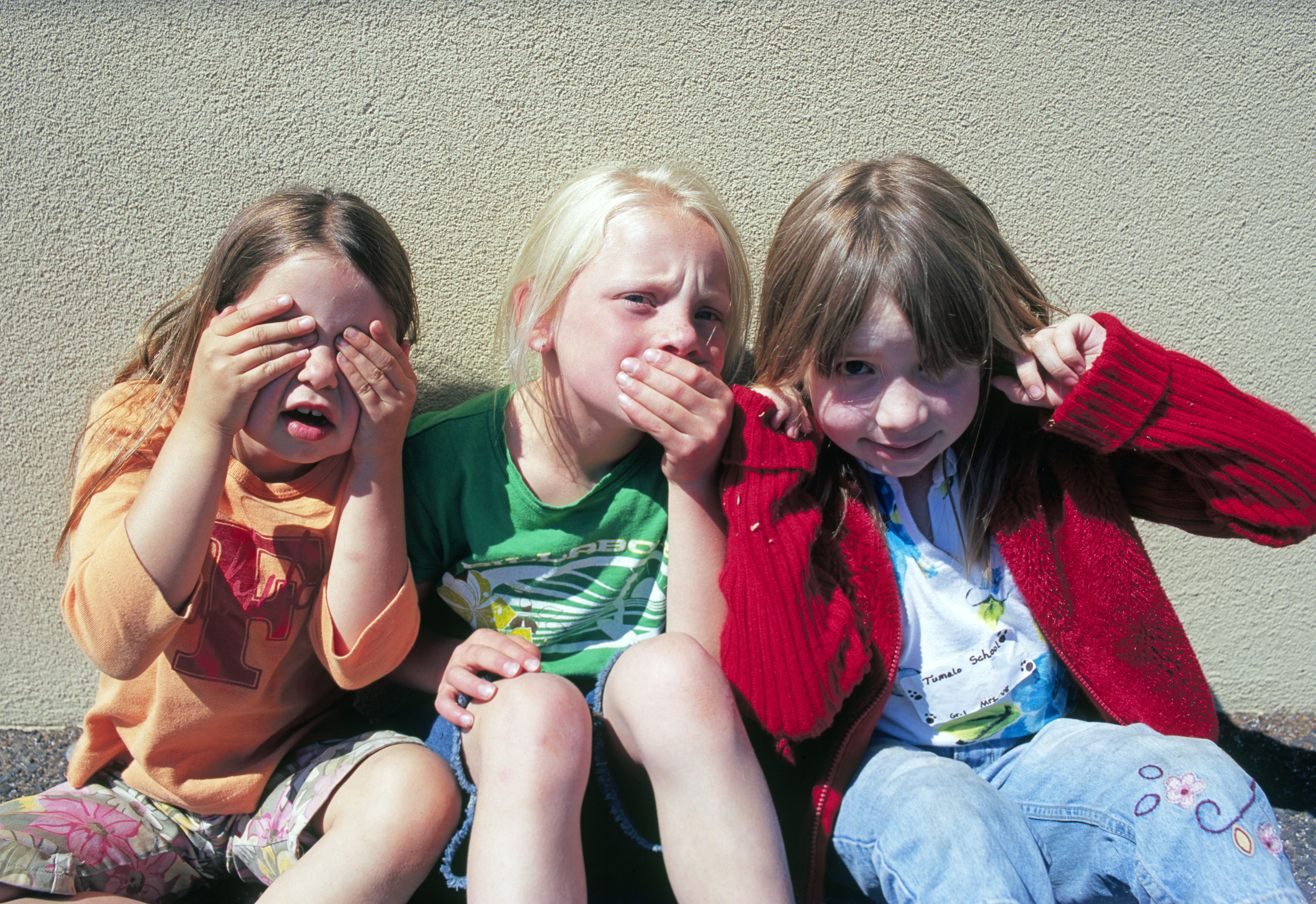 Three girls from the first grade at Tumalo Community School on the last day of school play see no evil hear no evil speak no evi