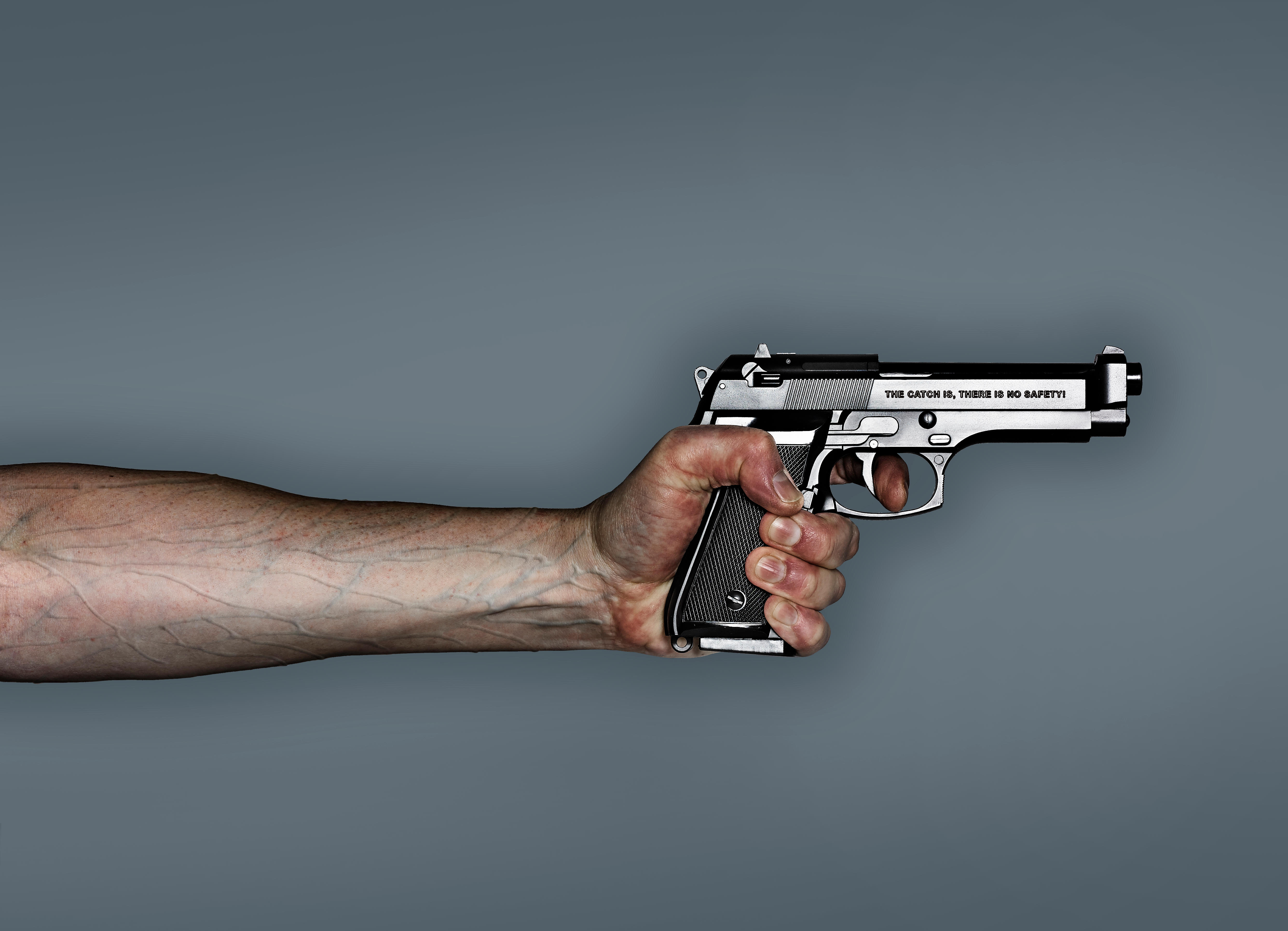 Hand holding revolver, anti gun campaign. The catch is, there is no safety