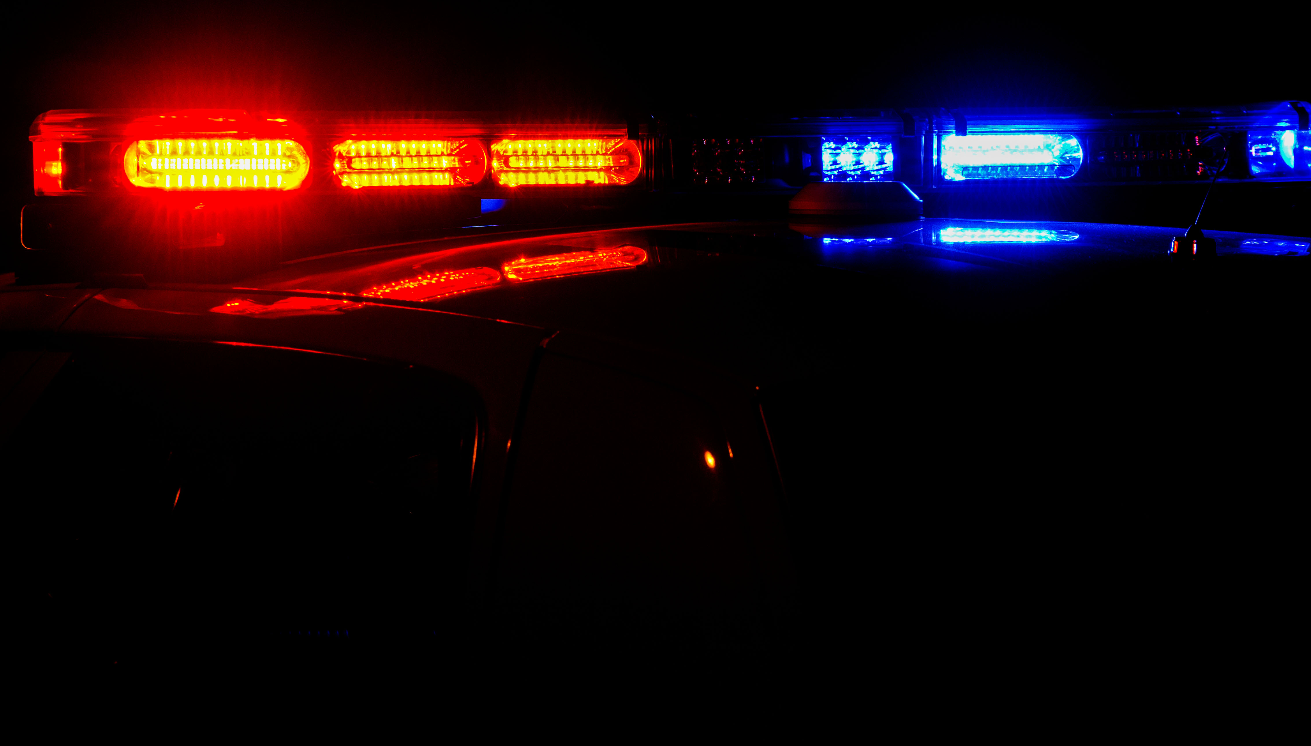 The top of a police car with its lights on at night.