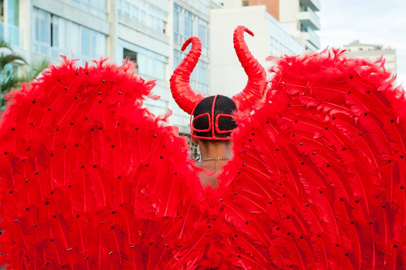 Back view of red feather wings and devil horns of a carnival costume at a street party in Ipanema, Rio de Janeiro