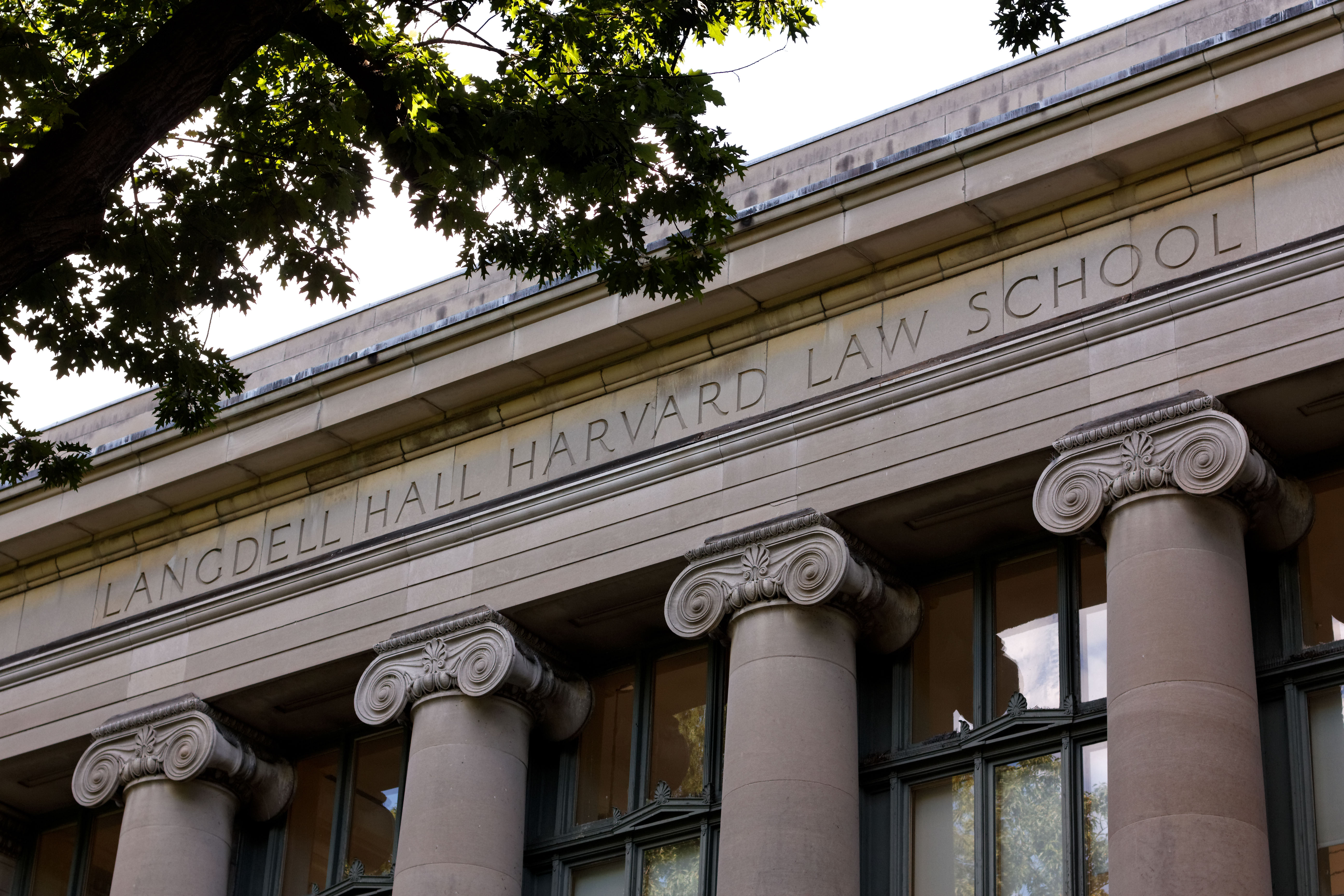 An angled shot of the letters "LANGDELL HALL HARVARD LAW SCHOOL" on the facade of the HLS main library in Cambridge, MA.