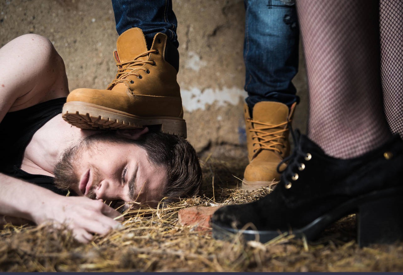 Closeup of a mans foot crushing man's head. Homophobic people