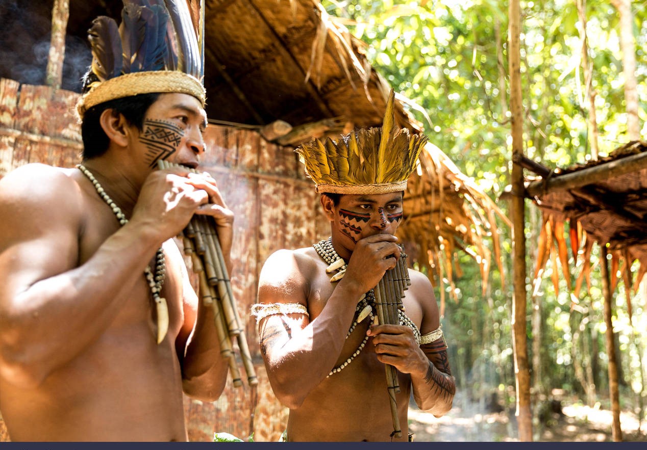 Native Brazilian playing wooden flute. Image shot 12/2015. Exact date unknown.