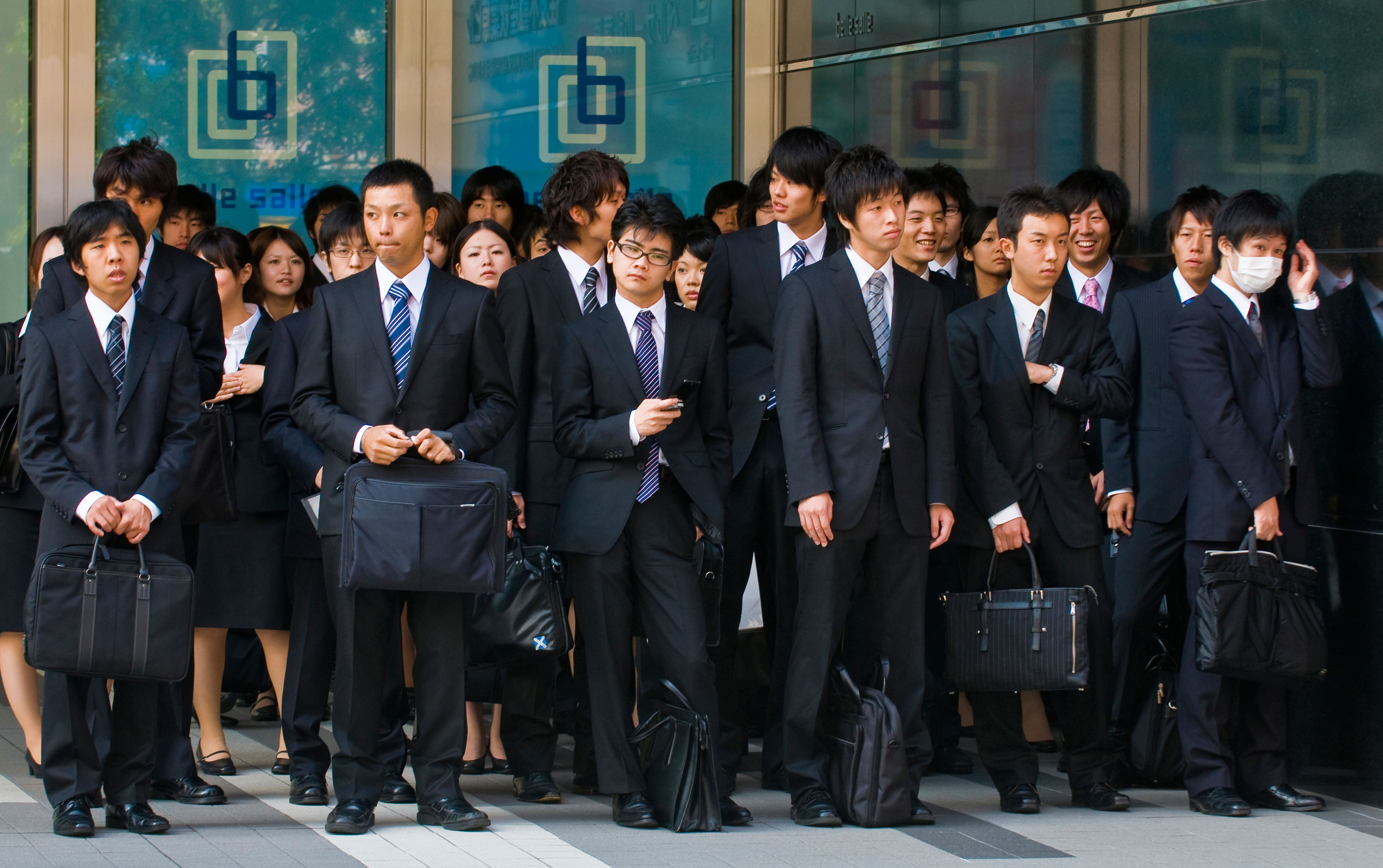 TOKYO - OCT 29 : Japanese office workers stands outside an office building in Tokyo Japan financial district on October 29 2009