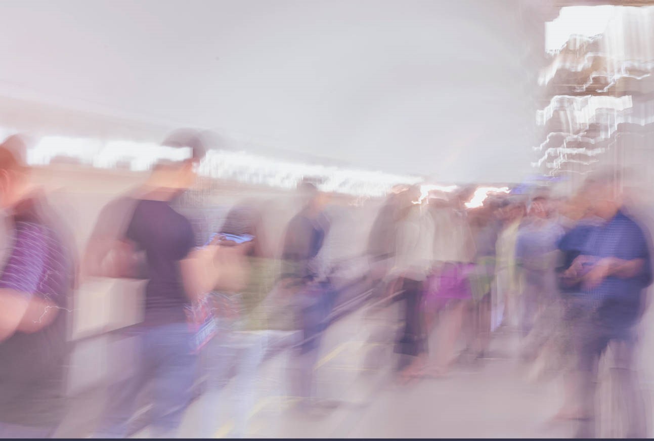 Abstract unrecognizable group of waiting for the train passengers in subway station. Blurred motion background, violet shades