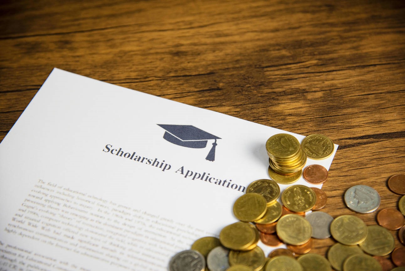 Scholarship application document contract form concept with money coin for grants scholarships education on wooden table