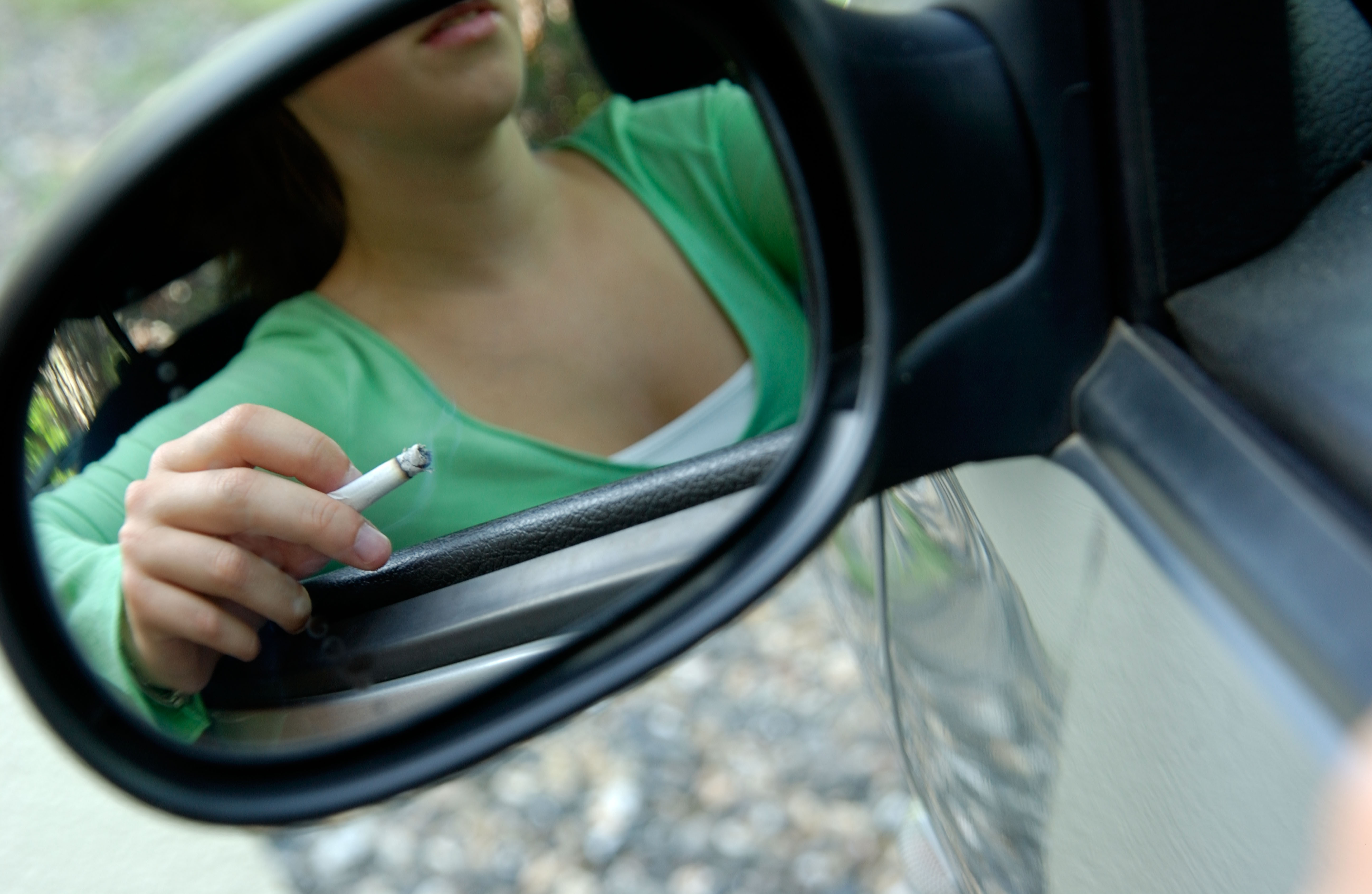 Smoking teenager in a car