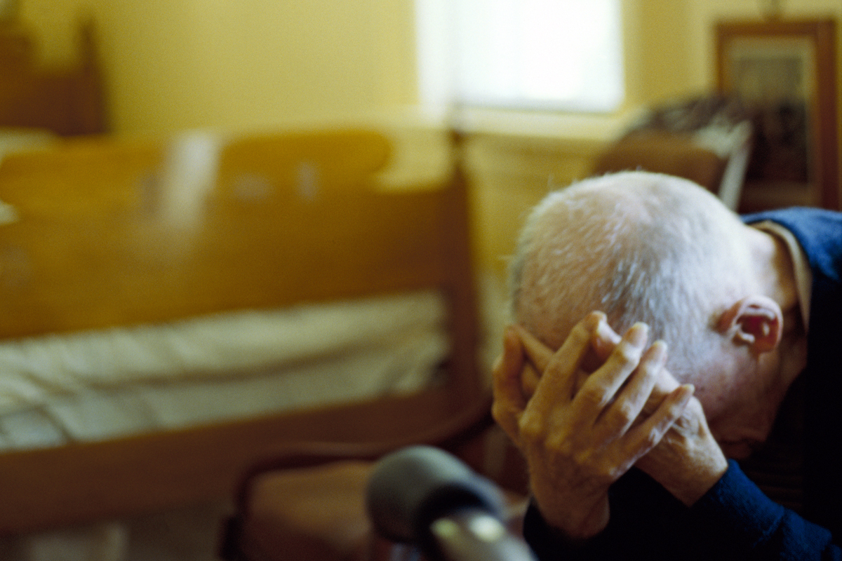 Elderly man in hands on head