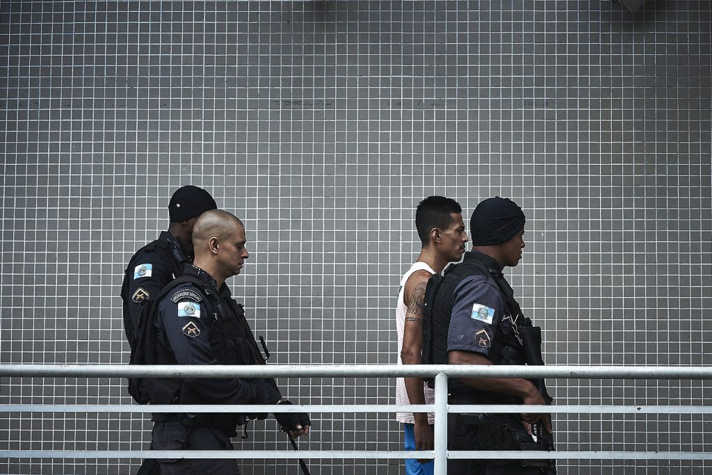 A man is lead to a a police station for questioning by detectives. (Photo: C.H. Gardiner)