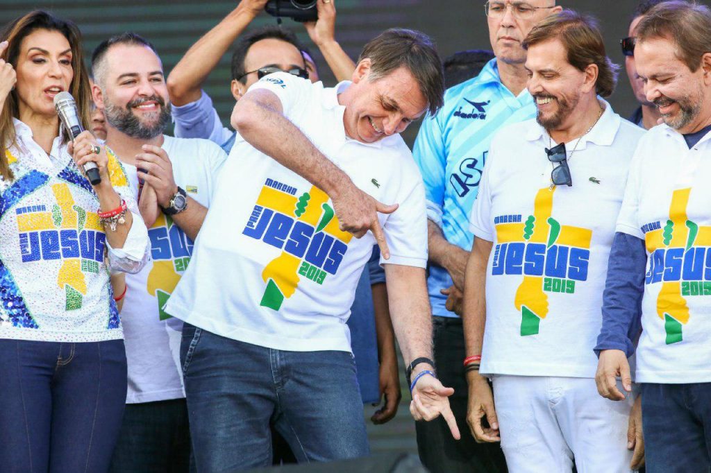 Brazilian President Jair Bolsonaro making finger-gun hand gestures during the March for Jesus this year.
