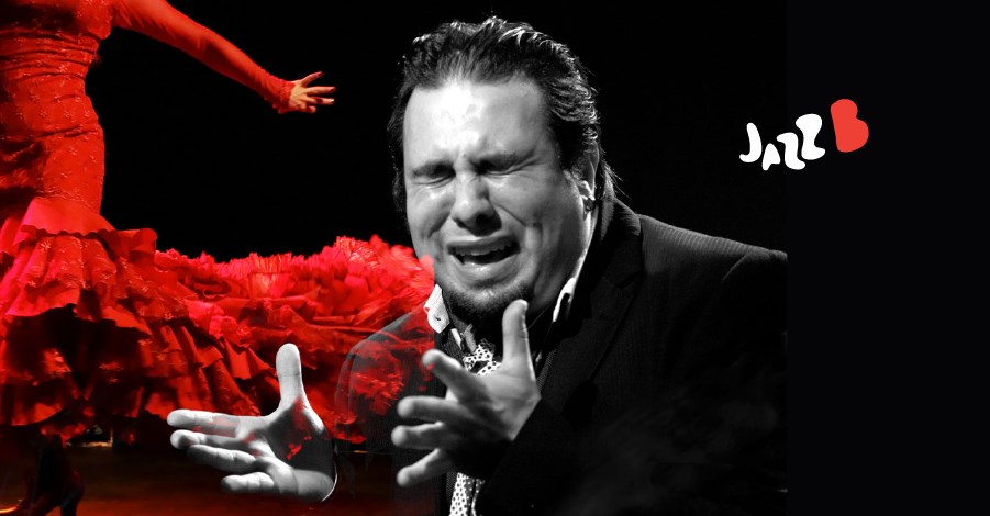 A flamenco performer in a red ruffled dress beside a singer in black