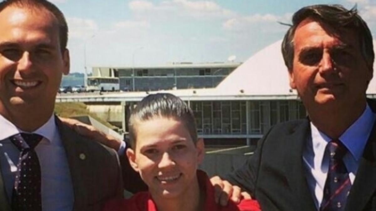 Karol Eller posing with Eduardo Bolsonaro (left) and Jair Bolsonaro (right).