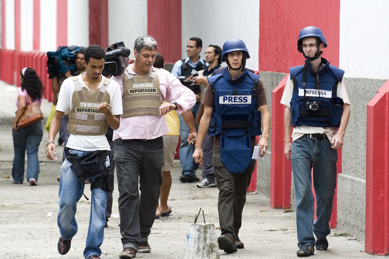 Journalists wearing bulletproof vests wa