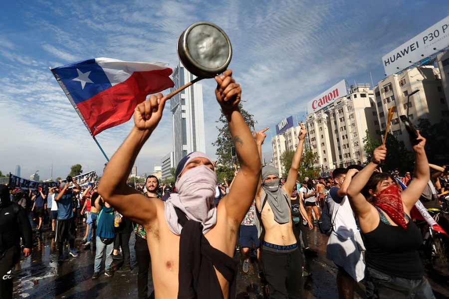 Demonstrators with a Chilean flag and pots at a protest in central Santiago
