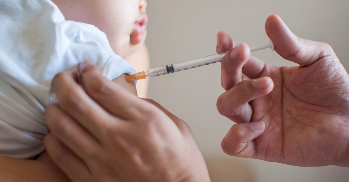 A doctor is injecting a vaccine to a baby boy