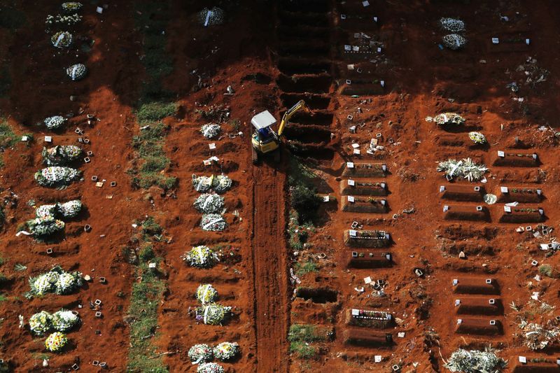 A gravedigger opens new graves with an excavator as the number of dead people rose after the coronavirus disease (Covid-19) outbreak, at Vila Formosa cemetery, Brazil's biggest cemetery, in Sao Paulo.