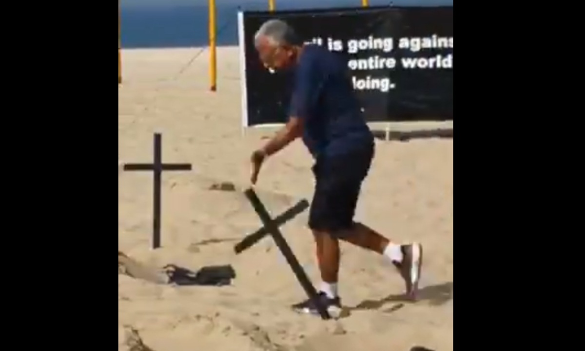 A man passed by the place and started knocking down the crosses while other demonstrators applauded the action and shouted Brazil.
