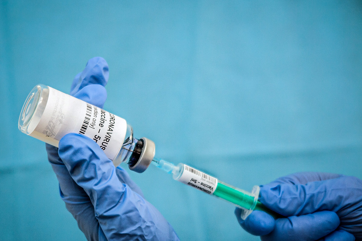 Infectious doctor fills injection syringe with CO-VID 19 vaccine - concept,  for prevention, immunization and treatment  for new corona virus infection(COVID-19,novel coronavirus disease 2019)