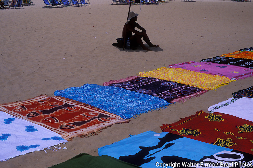 Street vendor at Copacabana beach, Rio de Janeiro, Brazil. Towels for sale, street-seller, informal economy, open-air market.