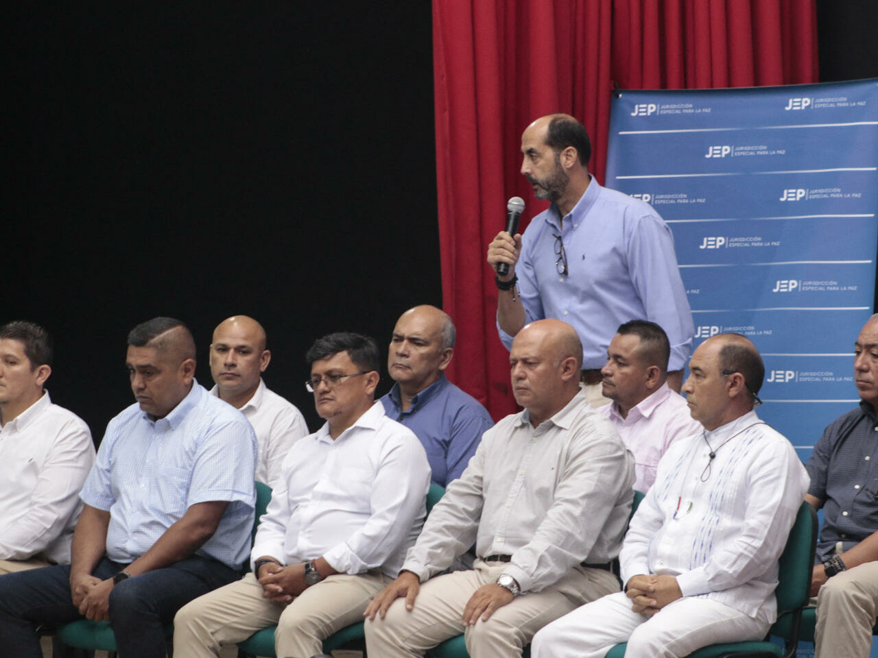 Former members of the Colombian Armed Forces speak in front of victims' families during a hearing organized by the Special Jurisdiction for Peace (JEP) in Ocana, Colombia, on April 26, 2022. - Ten retired members of Colombia's military on Tuesday began admitting to victims' families responsibility for the assassination of 120 civilians later presented as rebels killed in combat.