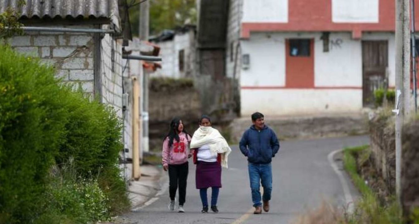 A group of people walk along an empty street on April 9, 2022, in Ambatillo.
