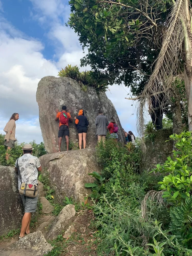 Tourists gather and embrace the central Menir.