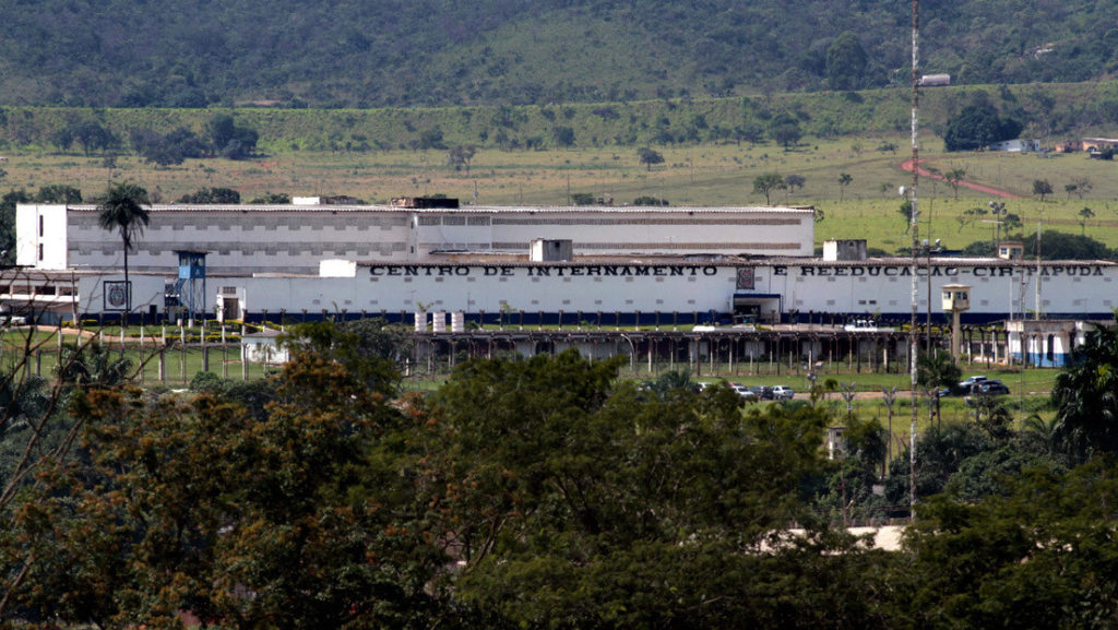 A long white prison building marked Centro de Internamento e Reeducacao CIR Papuda, with green hills behind it