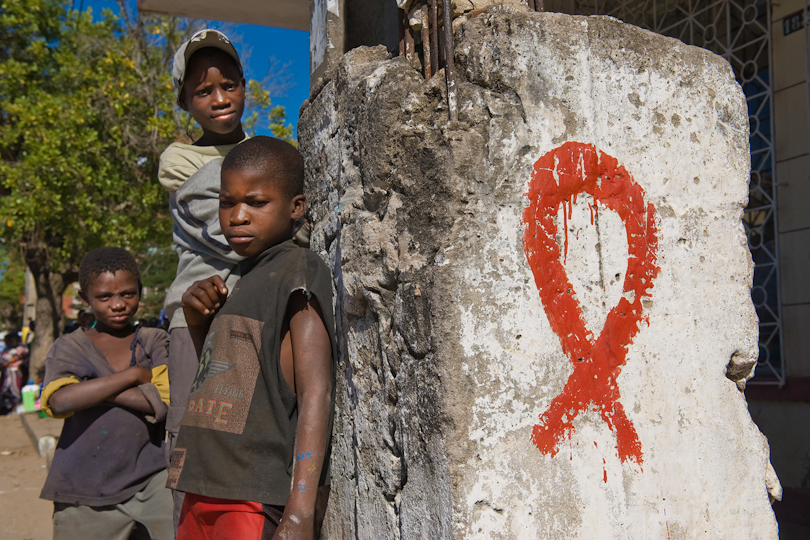 Street children at a pillar with painted HIV/AIDS ribbon Quelimane Mozambique