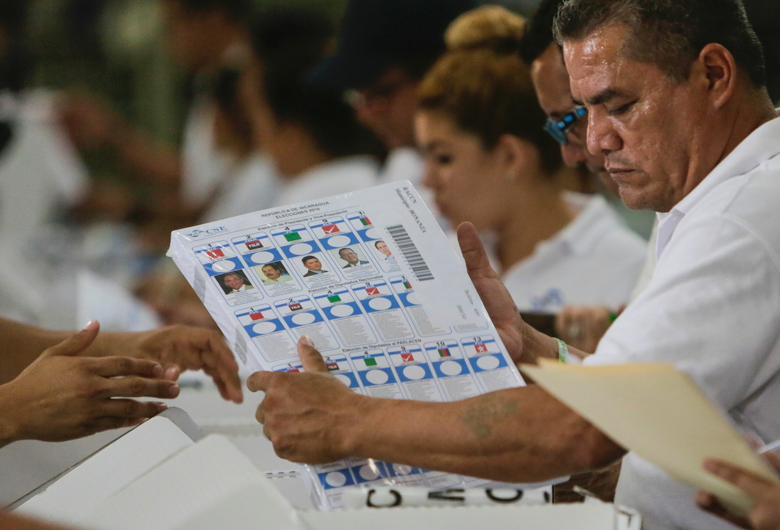 Election officials handling ballots in Nicaragua, illustrating the OAS Nicaragua vote