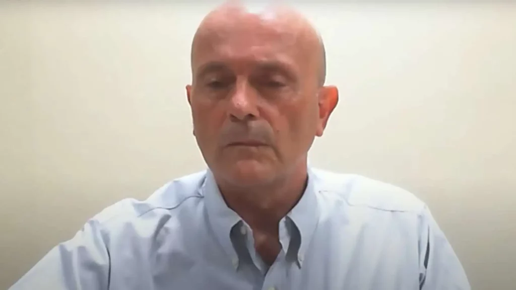 A bald man in a light blue shirt