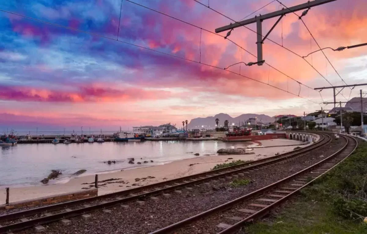 Railroad tracks curving along a harbor at sunset