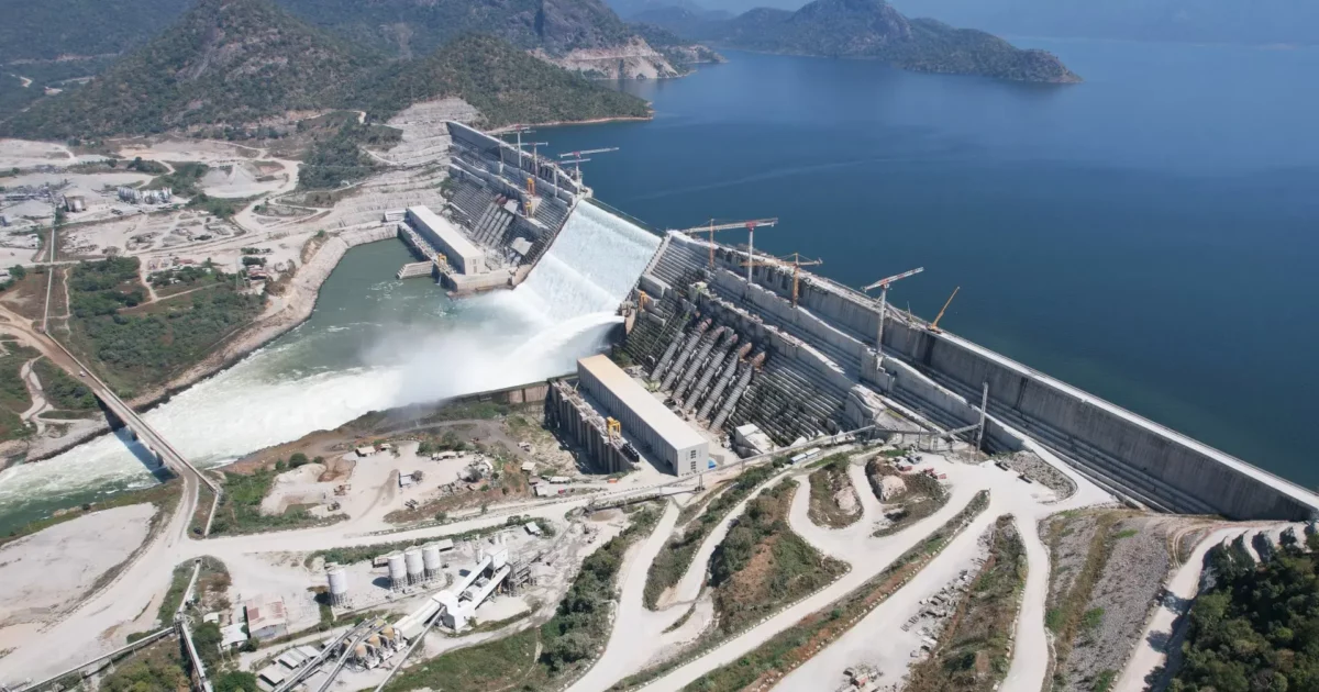 Large dam under construction with water flowing