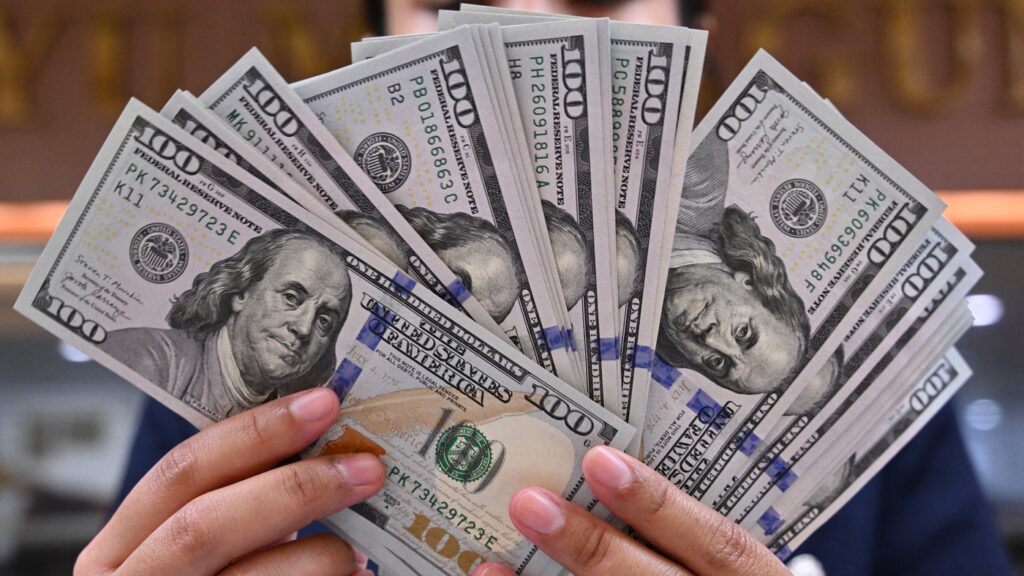Hands holding fanned out US dollar bills