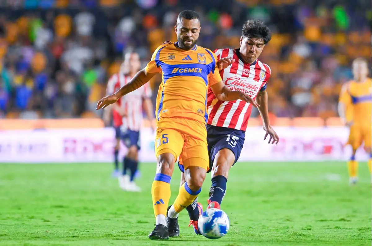 Tigres and Chivas players challenge for the ball in a Liga MX match