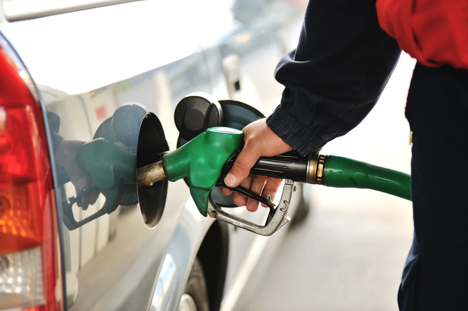 close-up-image-of-a-mens-hand-refilling-the-car-with-a-gas-pump-SBI-300934139
