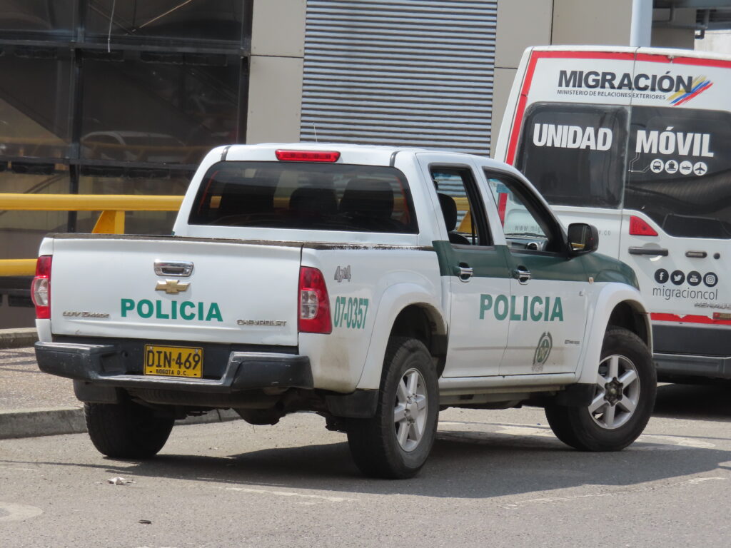Colombian police and migration vehicles parked on a street