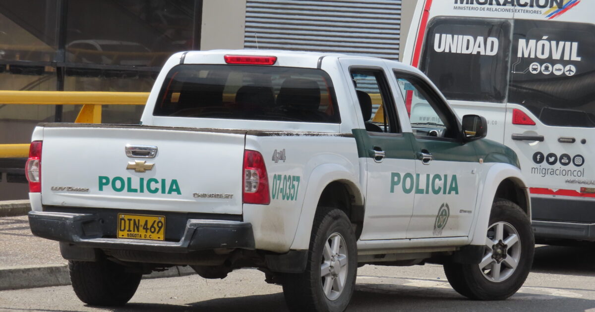 Colombian police and migration vehicles parked on a street