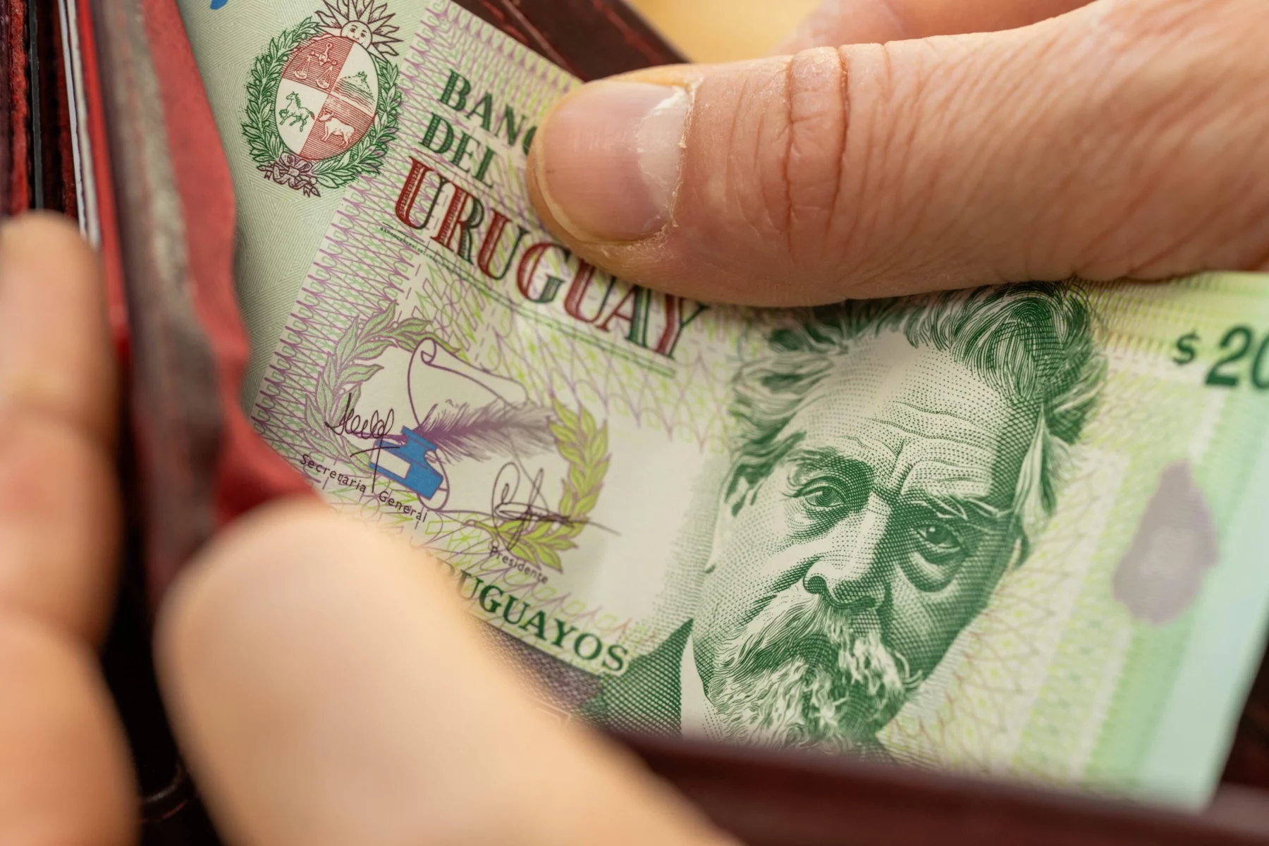 Uruguayan-money.-hands-opening-wallet-with-Uruguayan-peso-scaled